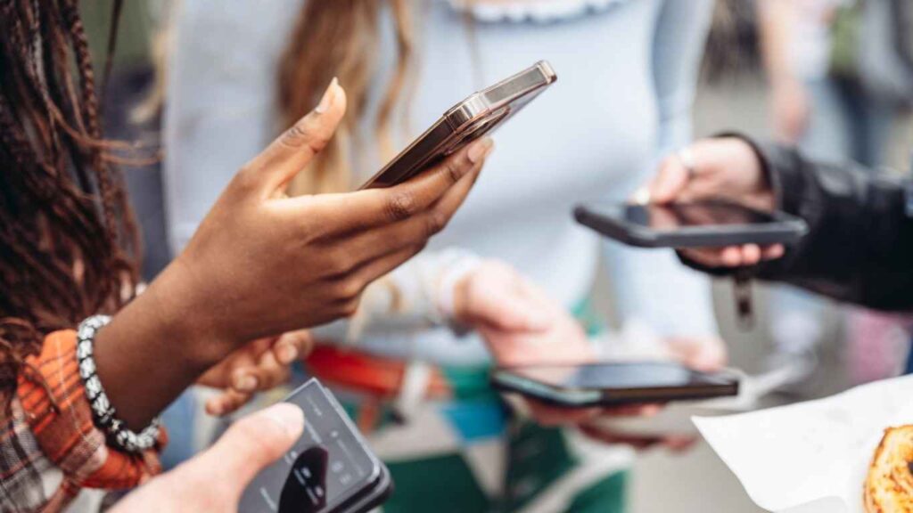 Personas utilizando teléfonos móviles para interactuar en plataformas digitales y redes sociales.
